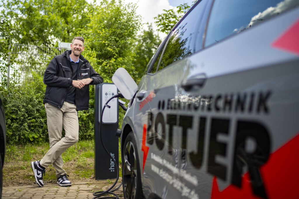 Inog Böttjer lehnt sich an einen Schnelllader an.